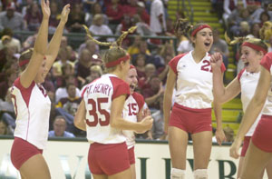 St. Henry's Danielle Everman, left, Christa Schwartz, 35, Kayla Lefeld, 15, and Lindsey Thobe, 21, celebrate their Division IV state semifinal win over Kalida on Friday night. St. Henry defeated Kalida in three games and will play Norwalk St. Paul for the state title today at 4 p.m.<br>dailystandard.com