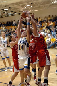 Marion Local's Maria Moeller, 14, battles with St. Henry's Brenda Hemmelgarn, right, and Kayla Lefeld, left, for a rebound during their game on Thursday night.<br>dailystandard.com