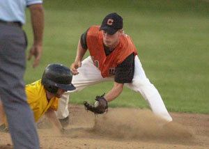 Coldwater's Cory Klenke, in orange, puts the tag on Fairview's Toby Hill, in yellow, during their state ACME tournament game at Veterans Field on Wednesday. Coldwater won the game 10-0 to advance to the final, to be played on Saturday.<br>dailystandard.com