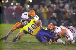 Coldwater's defensive trio of Trevor Stromblad, 7, Ryan Geier, 5, and Cody Muhlenkamp, 55, combine to make a tackle on St John's ball carrier Pat Kundert. Coldwater won the game, 35-21.<br></br>dailystandard.com