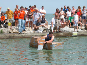 Ryan Snyder of Celina paddles his way to victory during the third annual Cardboard Duck Tape Boat Race held Saturday afternoon during the Celina Lake Festival. Snyder and his brother, Jason, took first place and were honored for their accomplishment with a ride on a parade float Saturday night. <br></br>dailystandard.com